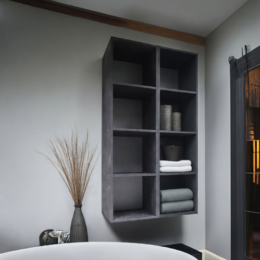 Room with a dark grey 4 compartment wall shelf holding towels and decorative items.