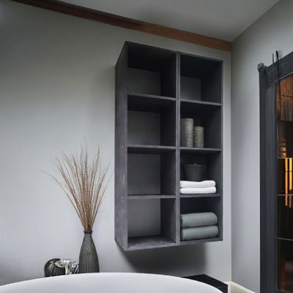 Room with a dark grey 4 compartment wall shelf holding towels and decorative items.
