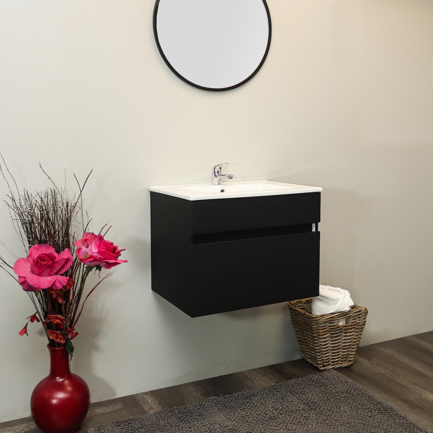 Bathroom setup with a black vanity unit, round mirror, and decorative elements.