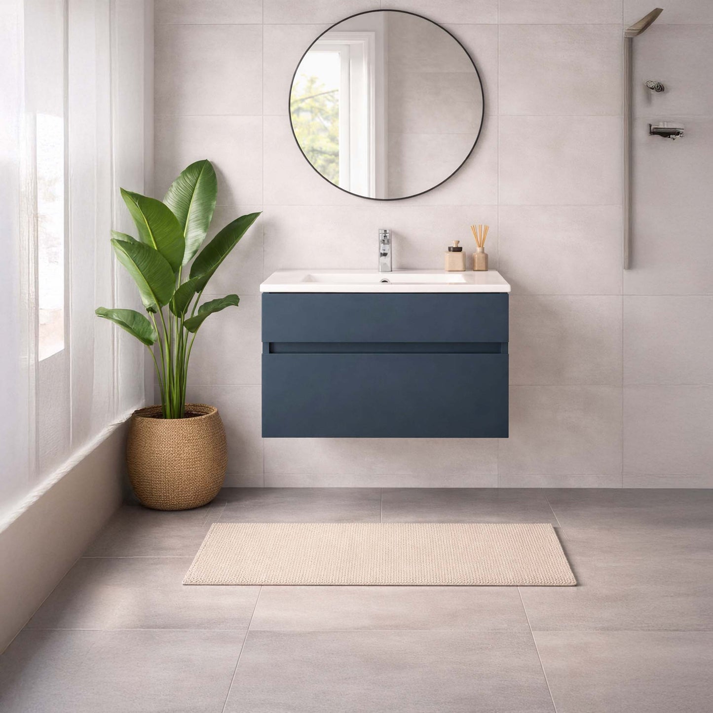 Bathroom with a blue vanity unit, round mirror, and plant