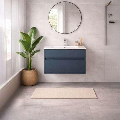 Bathroom with a blue vanity unit, round mirror, and plant