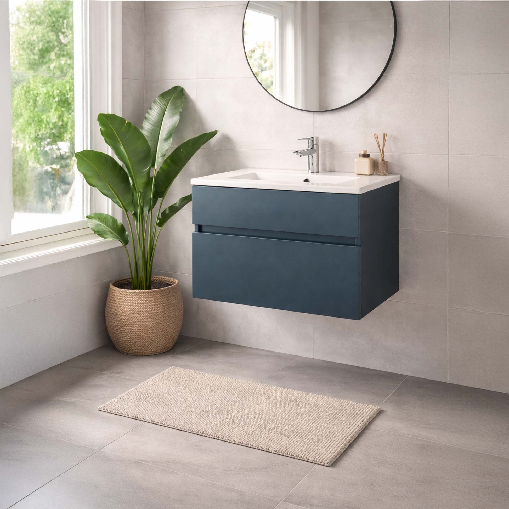 Bathroom with a blue vanity, white sink, and potted plant.
